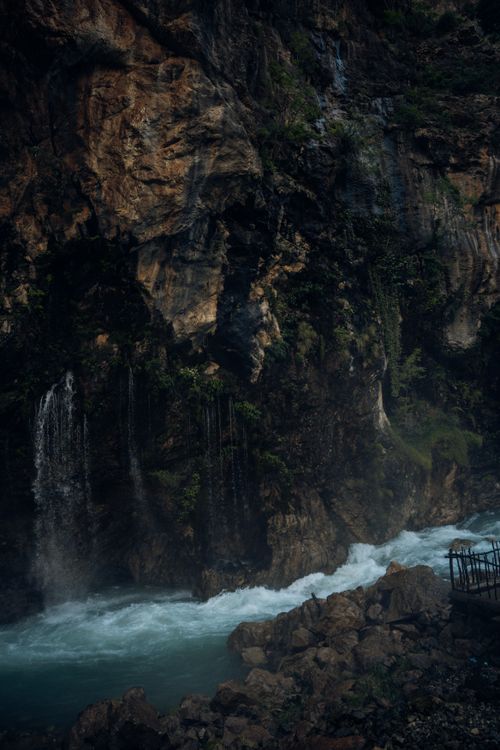 Free Dramatic waterfall flowing through a rocky canyon creates a breathtaking natural scene. Stock Photo