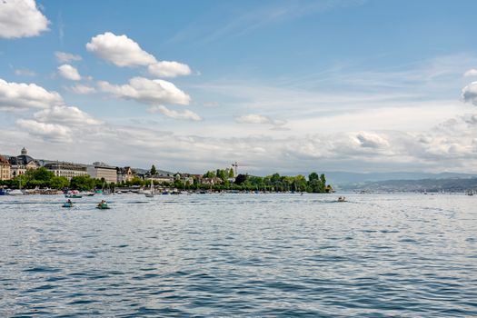 Scenic view of Lake Zurich with boats and cloudy sky on a sunny day.