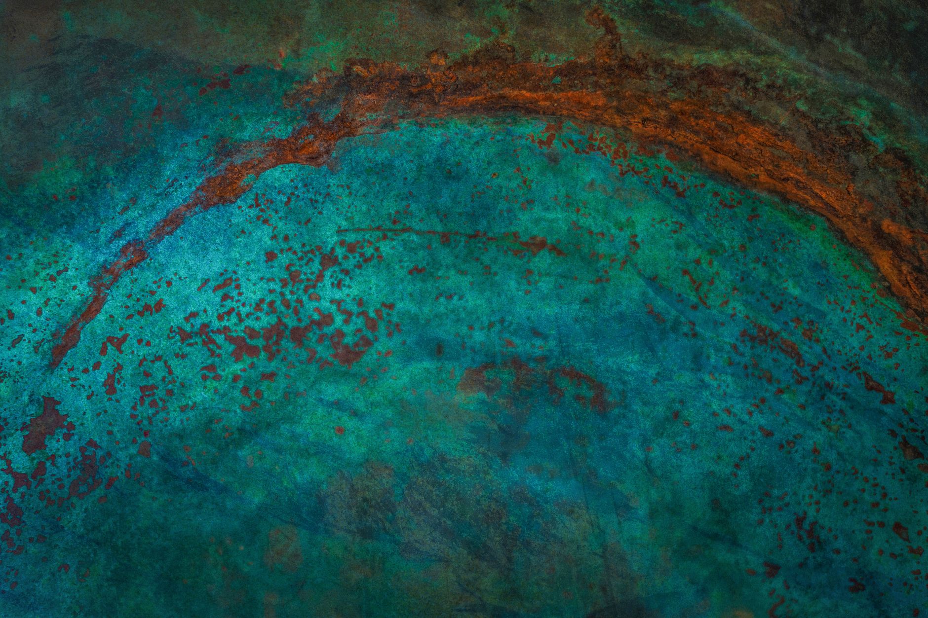 Close-up abstract of weathered metal surface with turquoise patina and rust details.