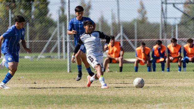 Action-packed capture of youth soccer players competing fiercely on the field during a sunny day.