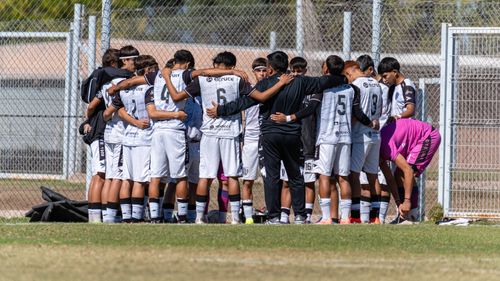 Free A youth soccer team huddles for motivation before a match on a sunny day. Stock Photo
