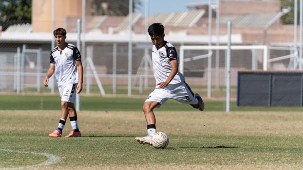 Two young soccer players in action on the field during daytime.