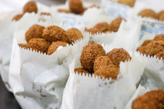 Close-up of freshly fried falafel served in paper wraps, capturing its crispy texture.