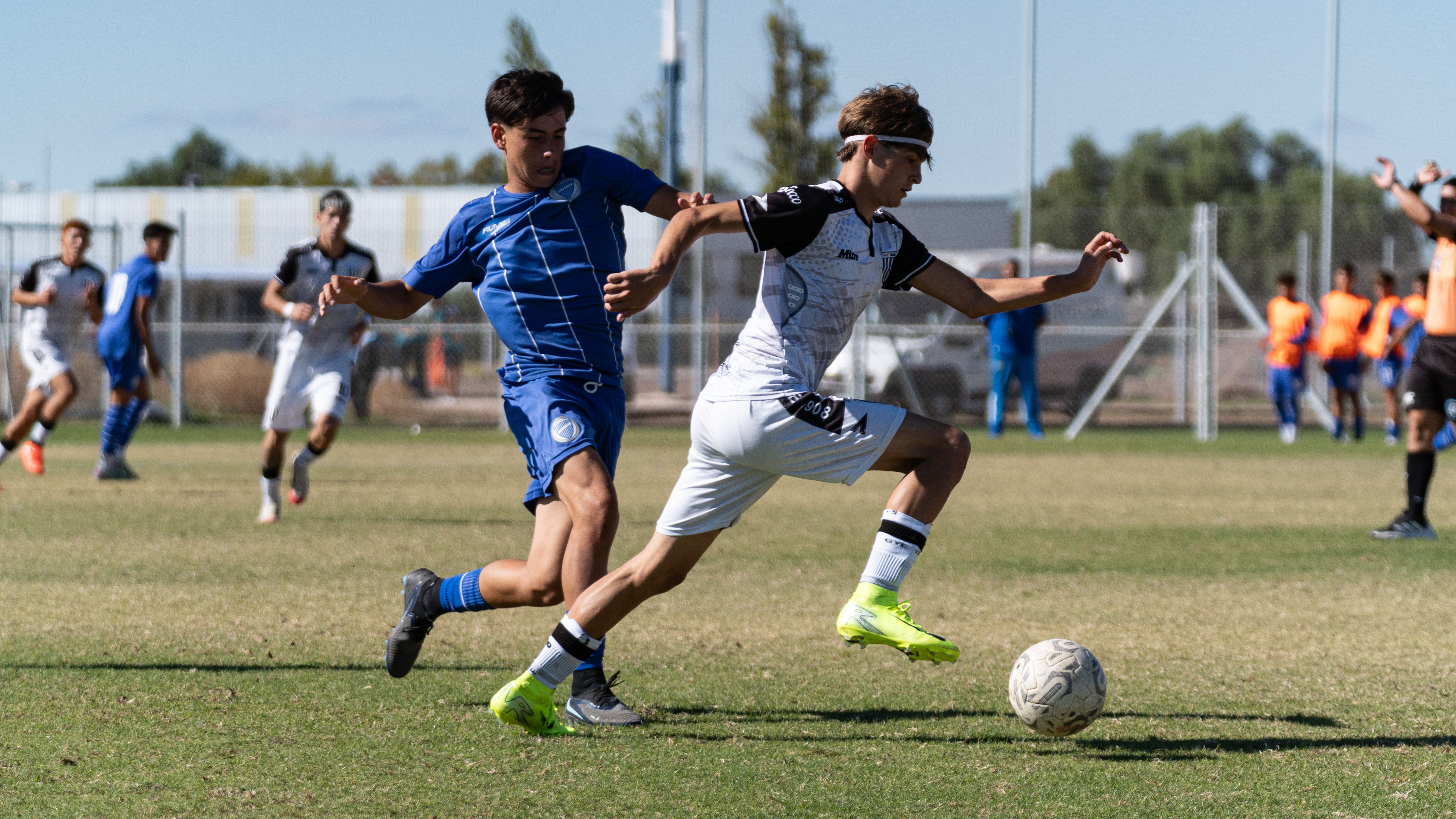Two soccer players in action during an outdoor match, showcasing skill and speed.