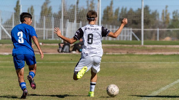 Two young soccer players in action on a sunny outdoor field.