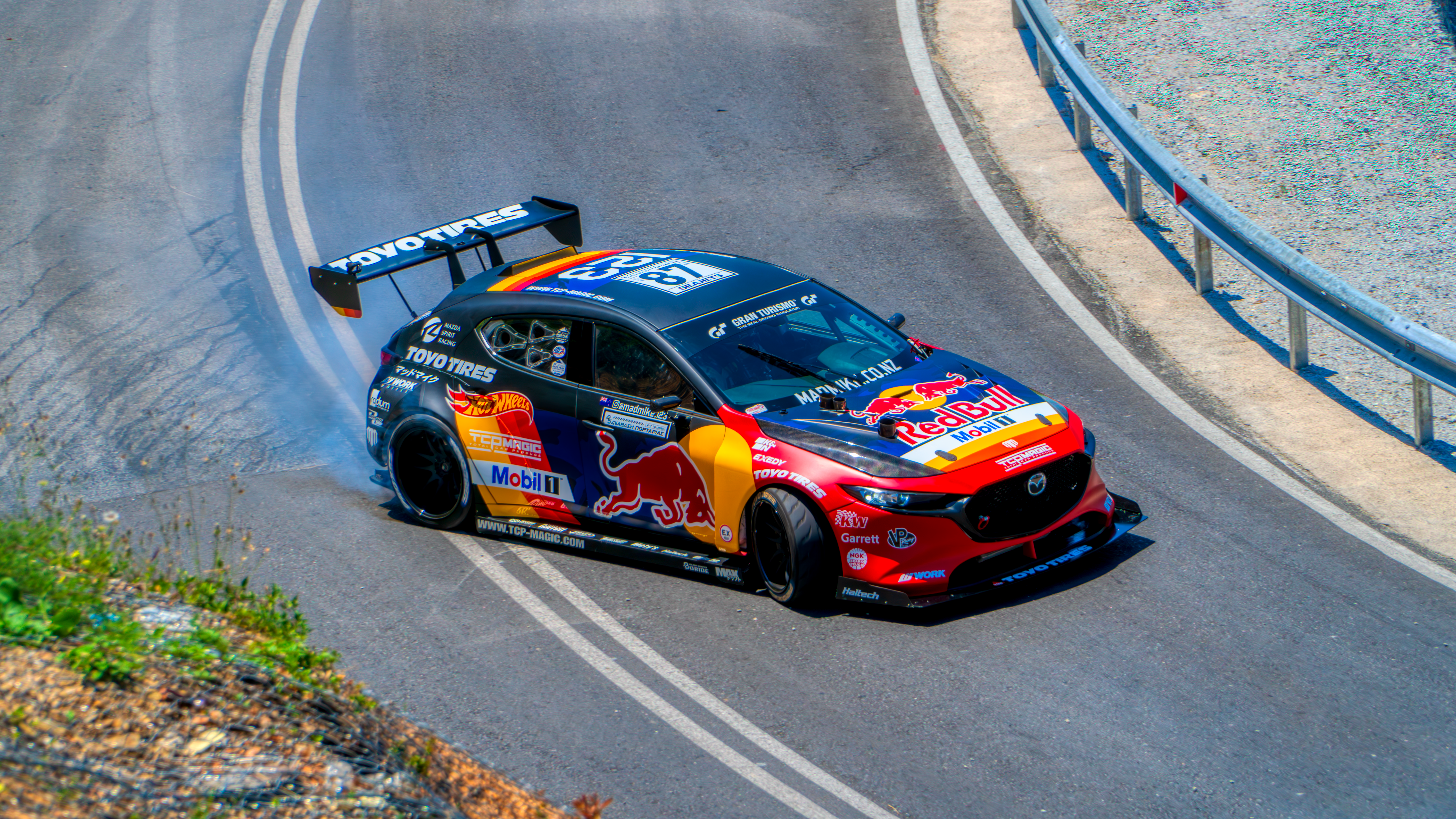Mazda car performing a thrilling drift on a winding mountain road in Portaria, Greece.
