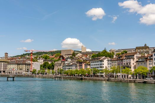 Beautiful waterfront scene in Zurich with historic architecture under a clear blue sky.