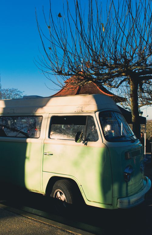 Free Vintage camper van parked under leafless trees on a sunny day. Stock Photo