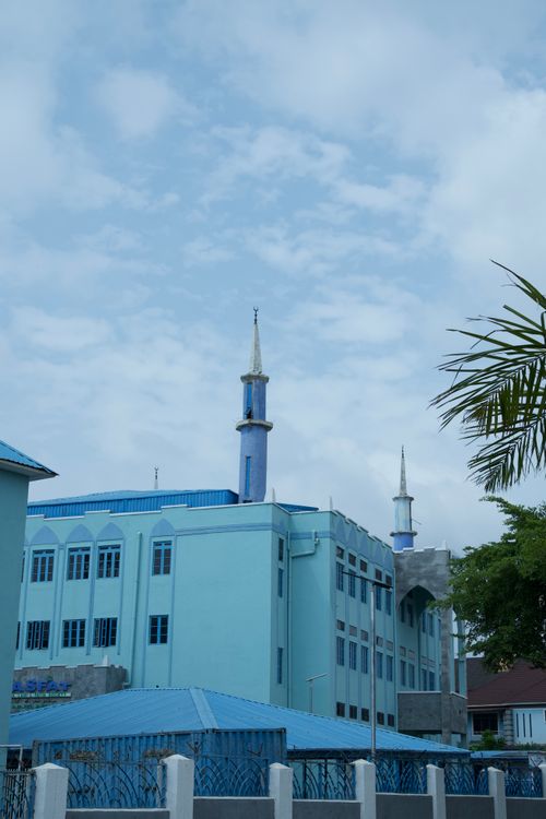 Free A serene view of a blue mosque with minarets under a cloudy sky in Abuja, Nigeria. Stock Photo