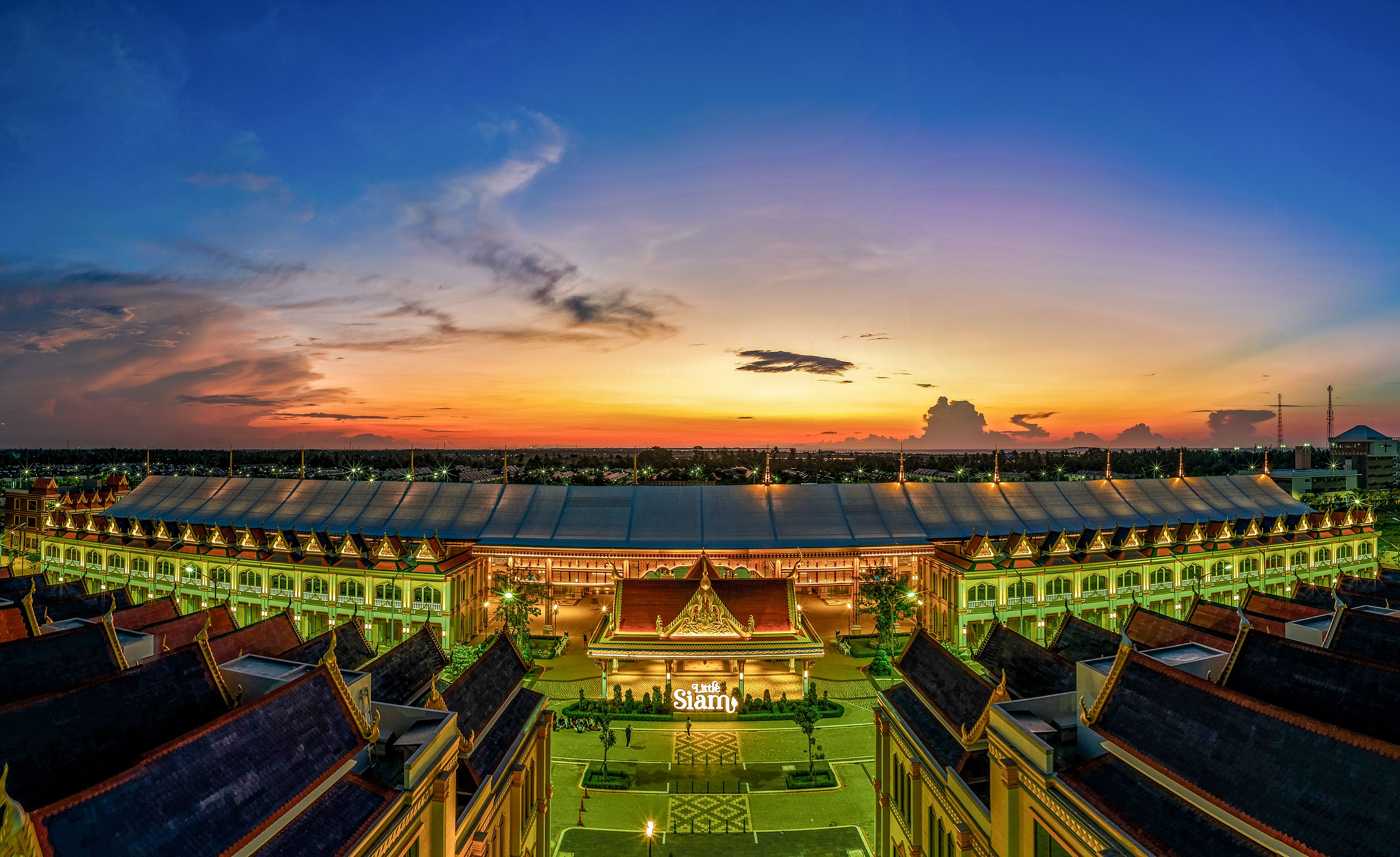 Stunning aerial view of Asian architecture with vibrant sunset sky, capturing cultural beauty.