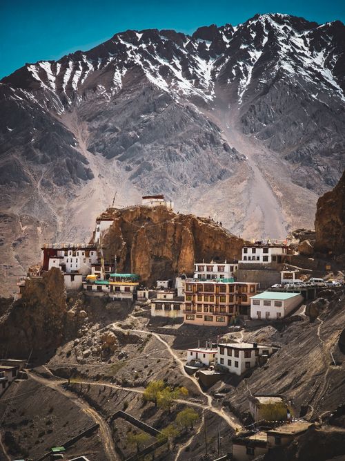 Free Picturesque Himalayan village beneath snow-capped mountains, showcasing unique architecture and natural beauty. Stock Photo