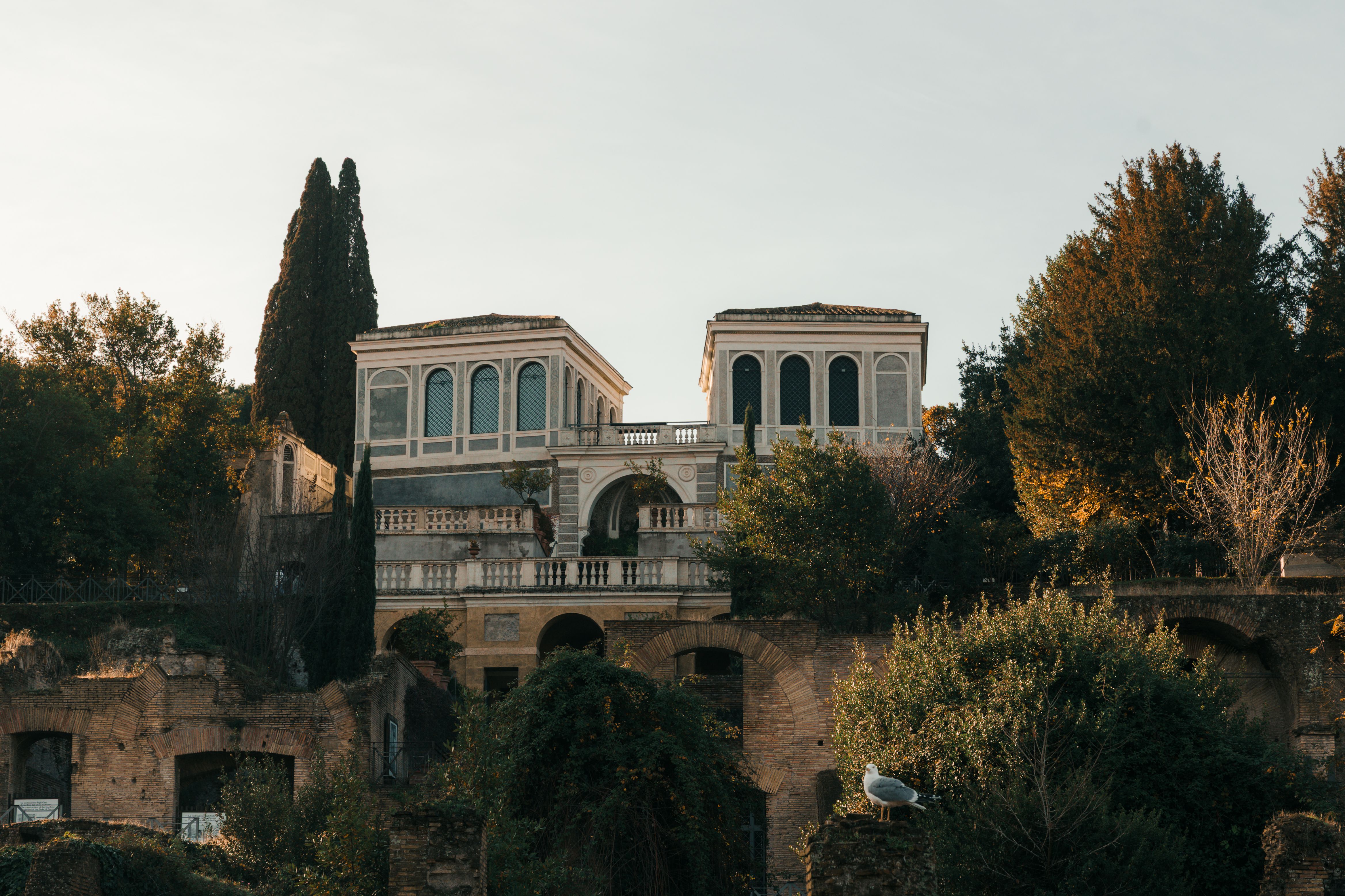 Scenic view of an ancient Roman villa on Palatine Hill surrounded by lush greenery.