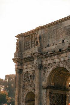 The majestic Arch of Constantine in Rome captured during sunrise in warm light.