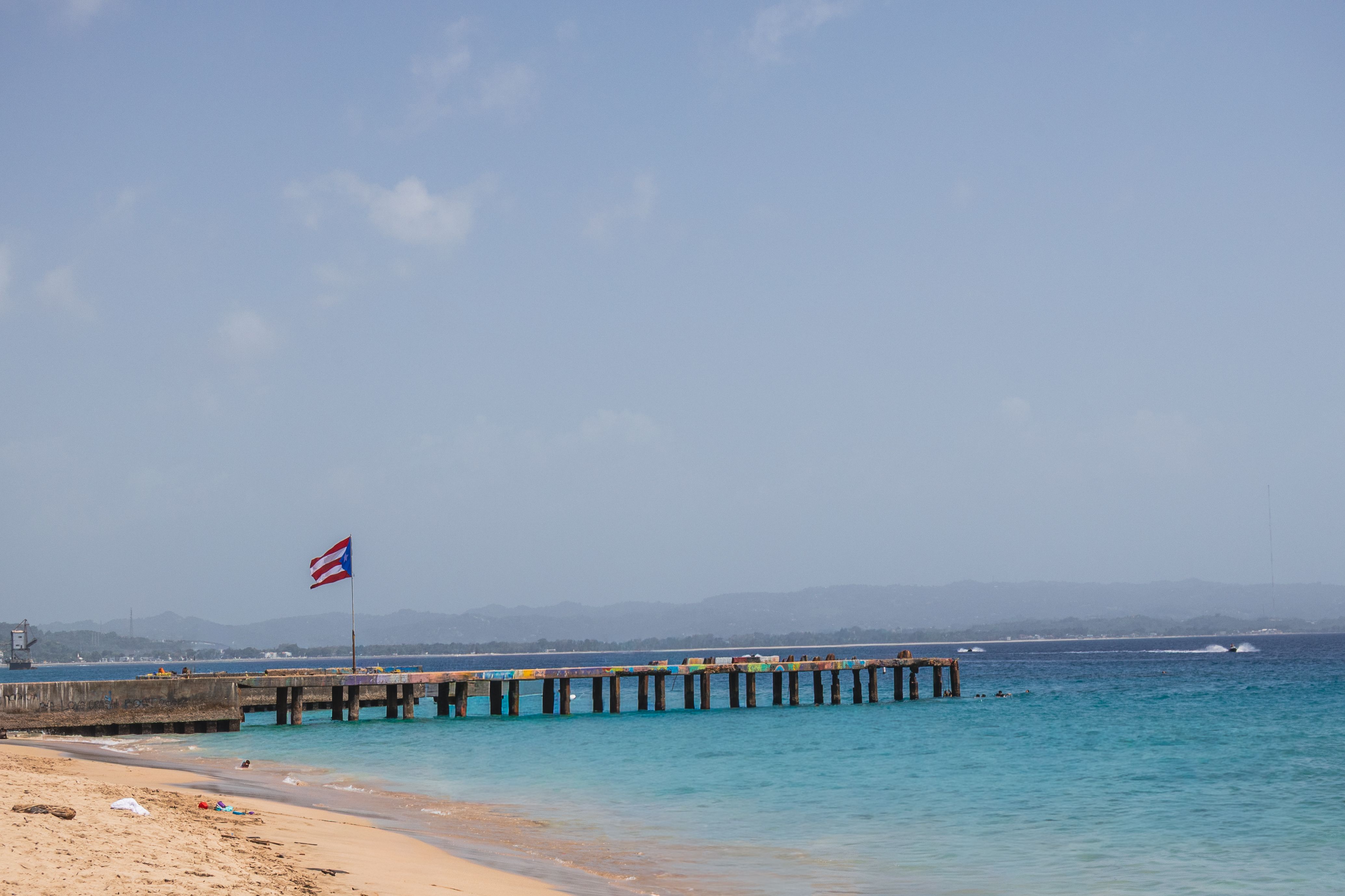 pier and Puerto Rican flag at a beach in Aguadilla Puerto Rico