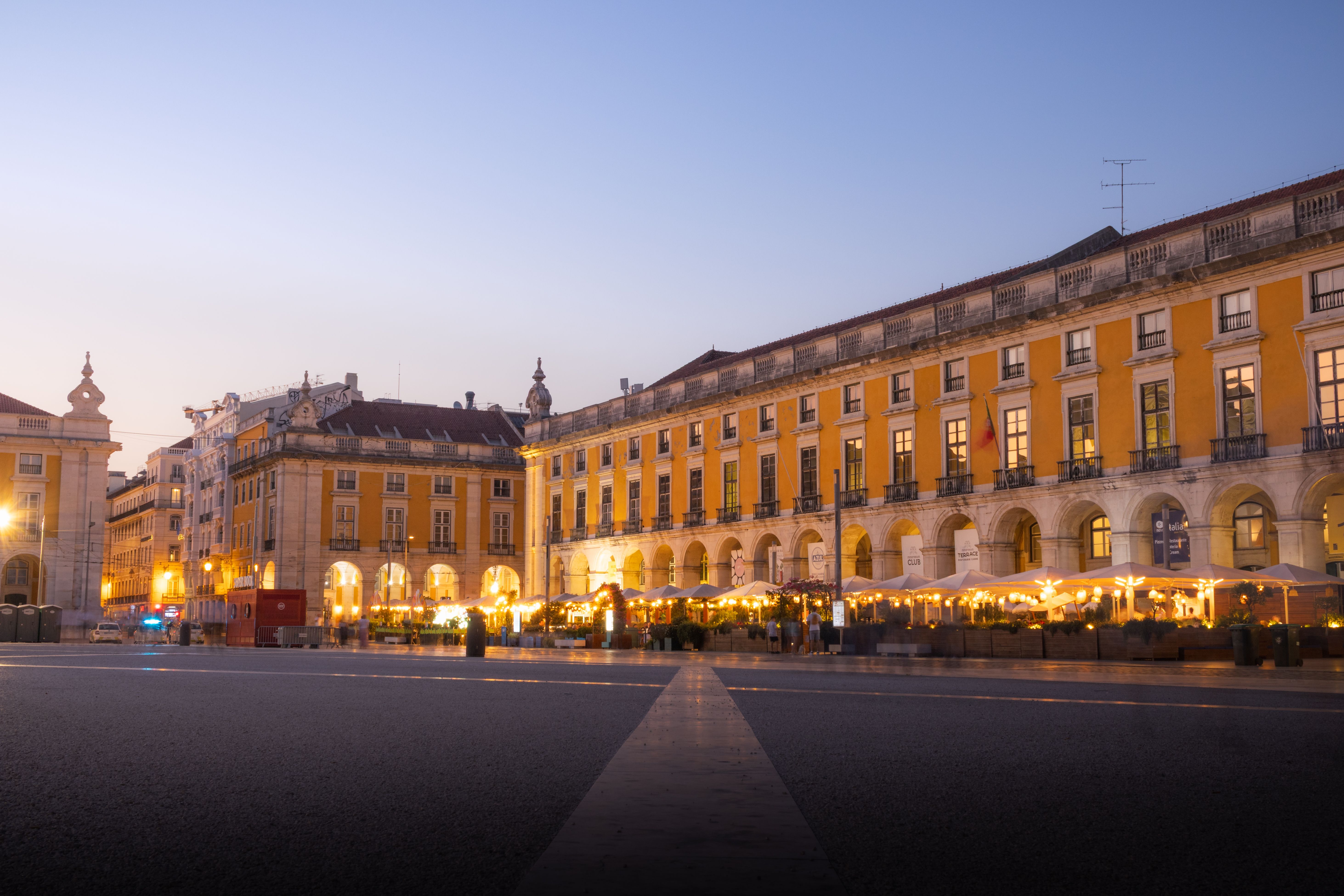 Evening crowd on a lit cobbled street in central Lisbon