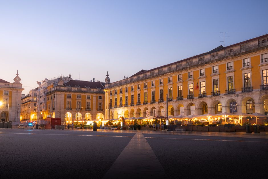 A vibrant <span class="notranslate"><em>praça</em></span> in Lisbon filled with people enjoying the evening light.