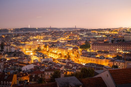 A breathtaking view of Lisbon at twilight showcasing the illuminated cityscape and iconic 25 de Abril Bridge.
