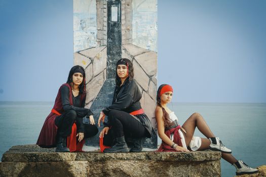 Three women dressed in pirate costumes pose outdoors against a coastal backdrop in Puerto Rico.
