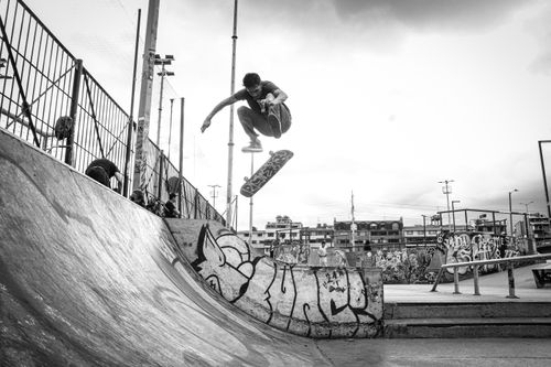 Free High-energy black and white shot of a skateboarder performing a trick at a Bogotá skatepark, showcasing urban skate culture. Stock Photo