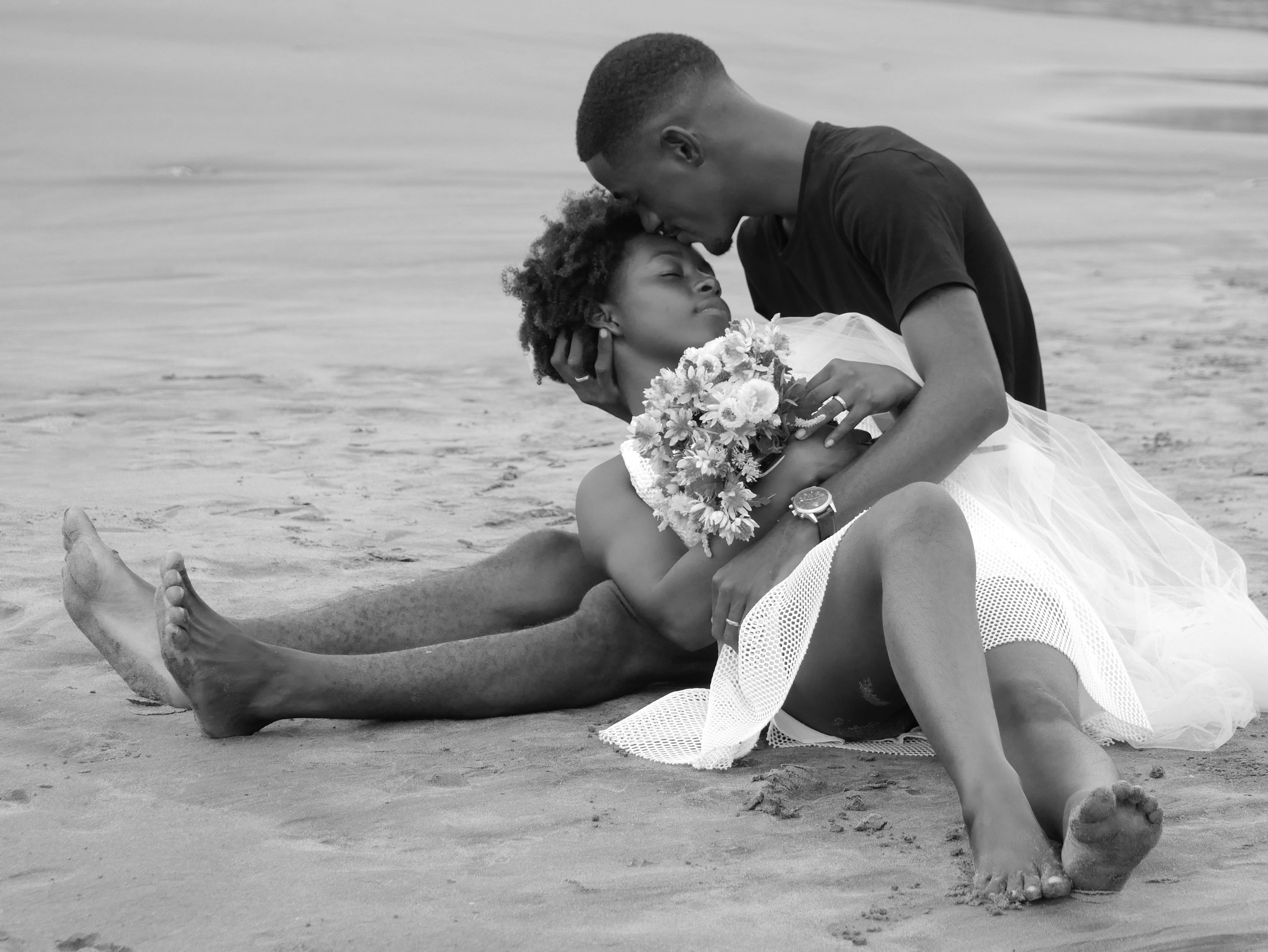 man and woman kissing on beach