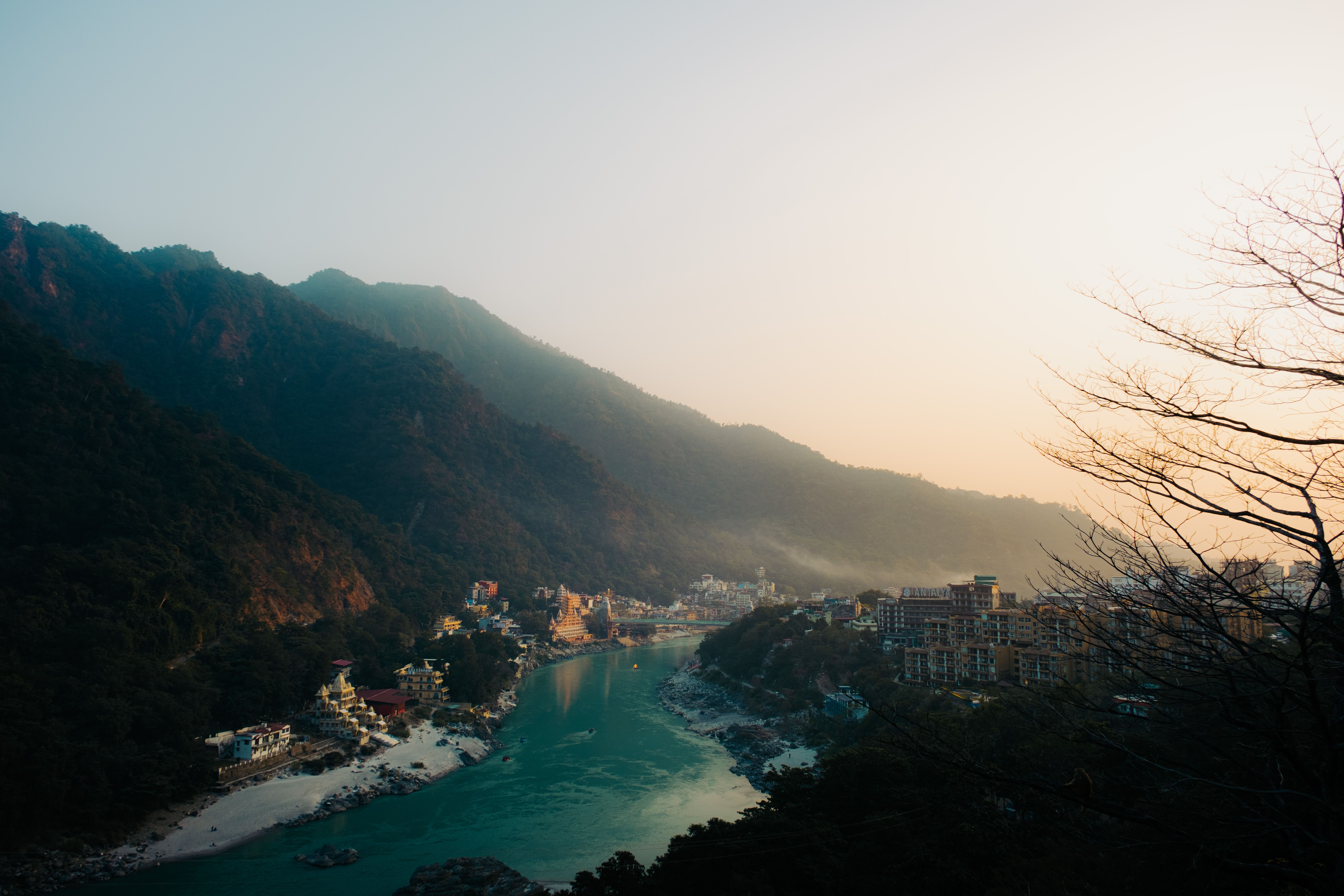 A beautiful view of Rishikesh with mountains and river Ganges during sunset, offering a serene landscape.