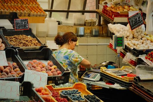 A vibrant market stall in Budapest showcasing fresh produce and a vendor at work.