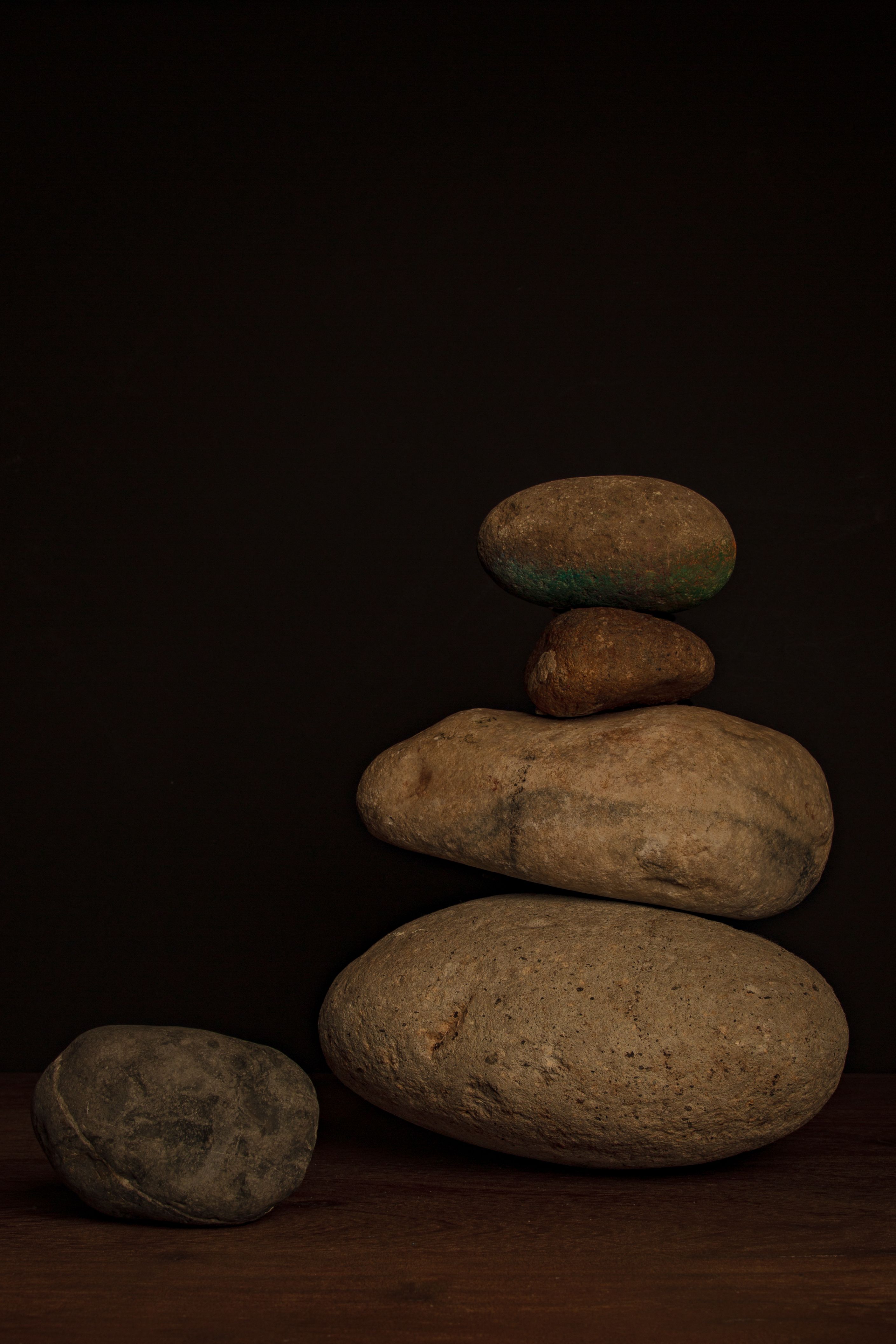 Stacked stones creating a calm and minimalist composition with a dark backdrop.