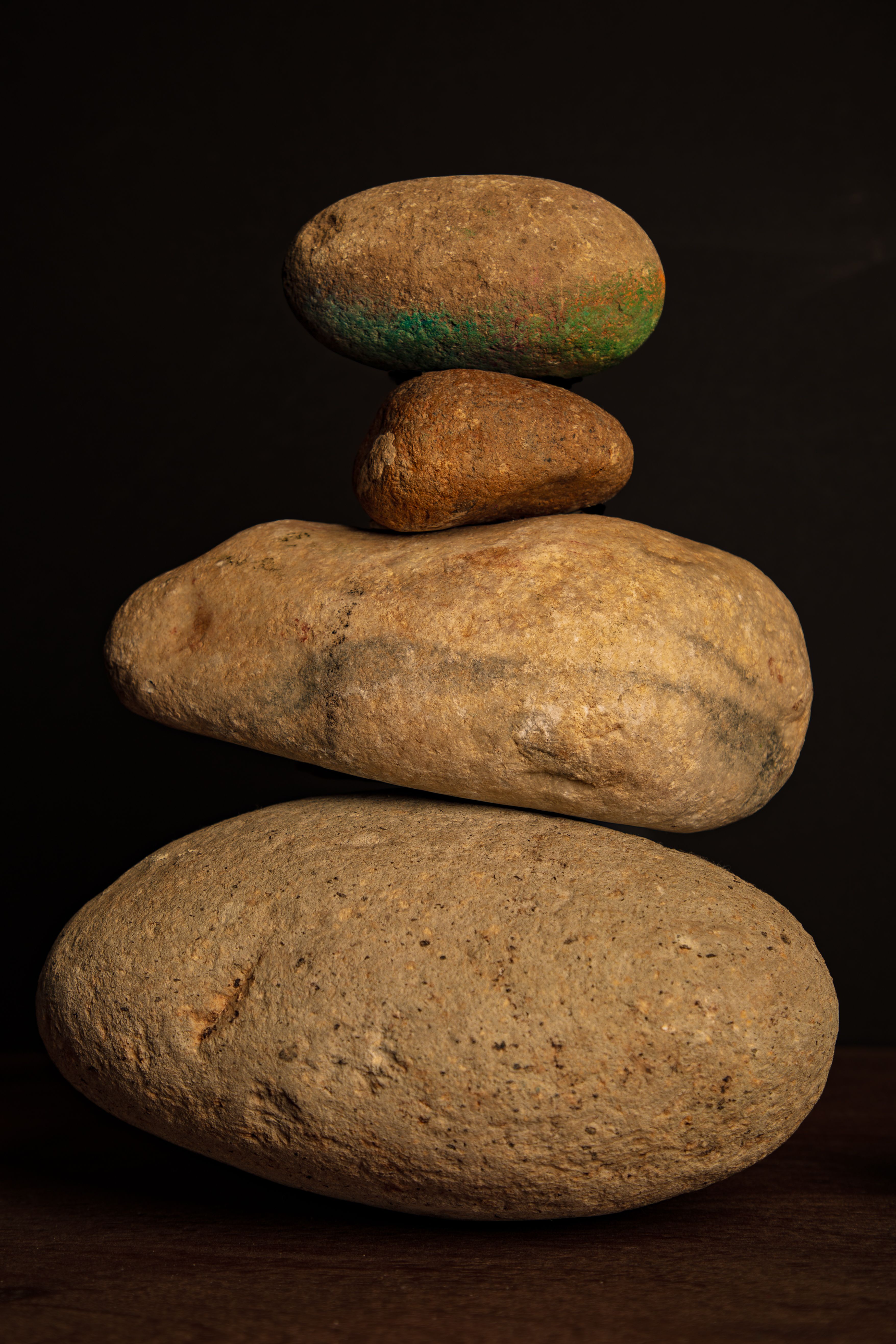 Zen stone tower symbolizing balance and tranquility on dark backdrop.