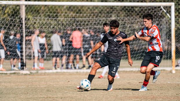 Two soccer players in action during a competitive match outdoors.
