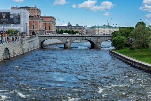 Free Charming view of a bridge over a river in central Stockholm on a sunny day. Perfect blend of urban architecture and natural beauty. Stock Photo