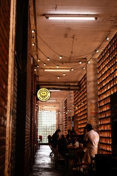 Ambient alley scene with people dining at an urban cafe, warm lighting.