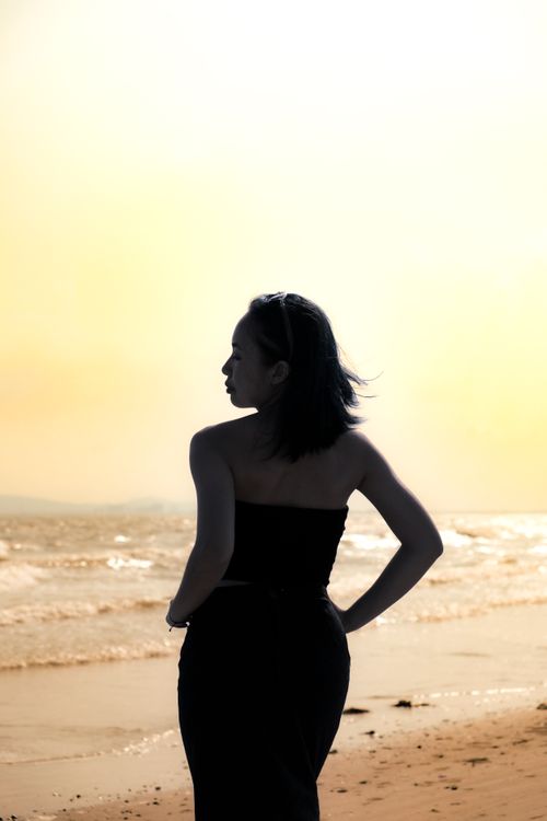 Free A woman stands by a Vietnamese beach, embracing a tranquil sunset vibe and natural beauty. Stock Photo