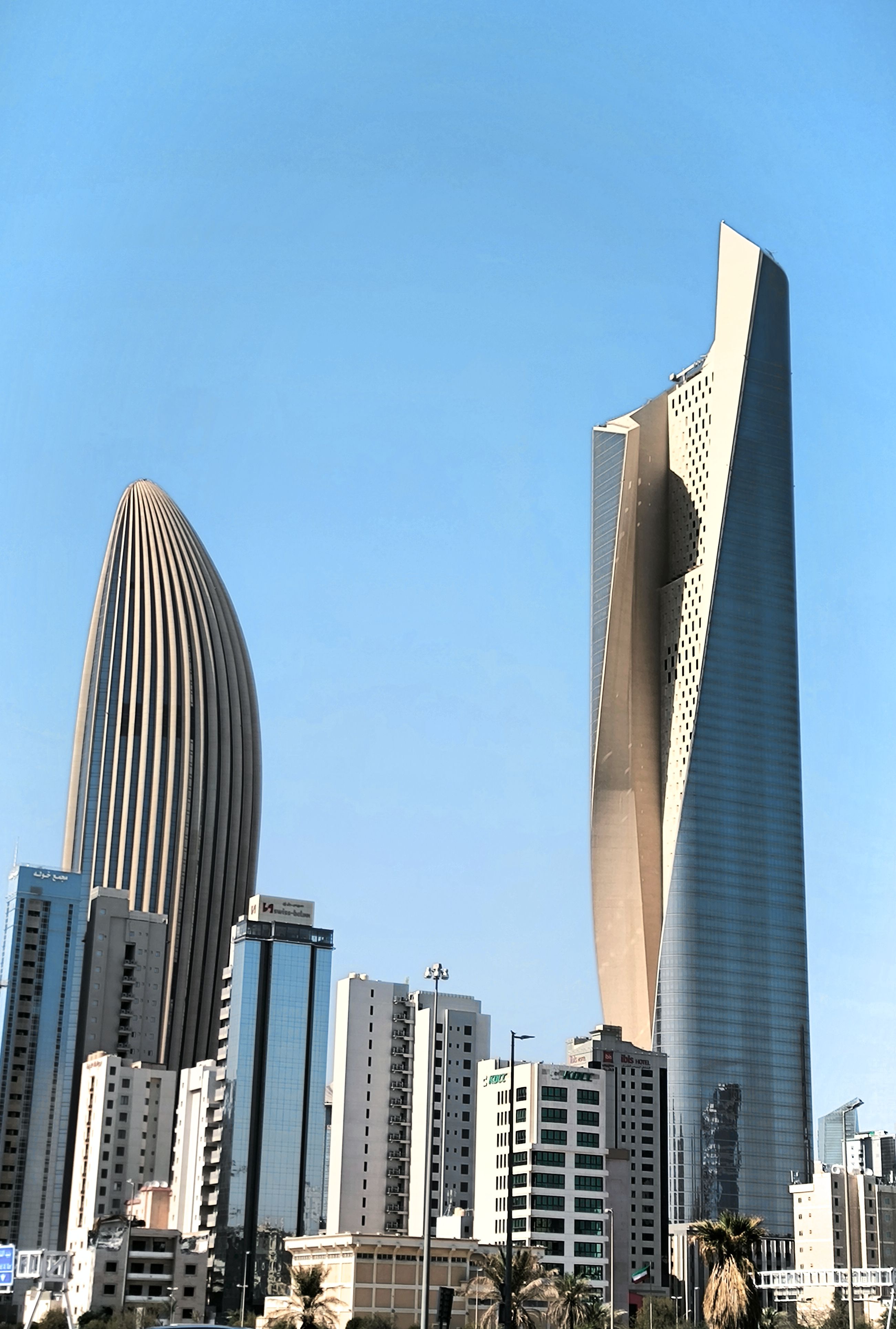 Skyscrapers against a clear blue sky in Kuwait City, showcasing modern architecture.