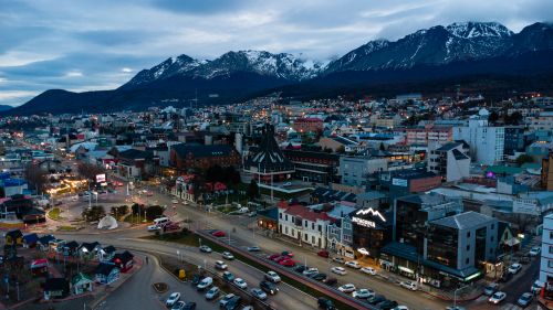 Free Aerial view of Ushuaia, Argentina, showcasing cityscape against snow-capped mountains during twilight. Stock Photo