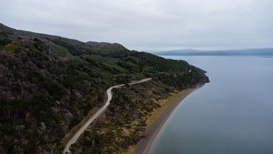 Best Private Excursion to Both Sides of the Iguaçu Falls Review 2026 - Aerial view of a winding coastal road along the rugged landscape of Ushuaia, Argentina.