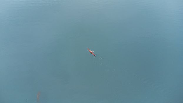 A lone kayaker paddles through the serene waters of Ushuaia, Argentina.