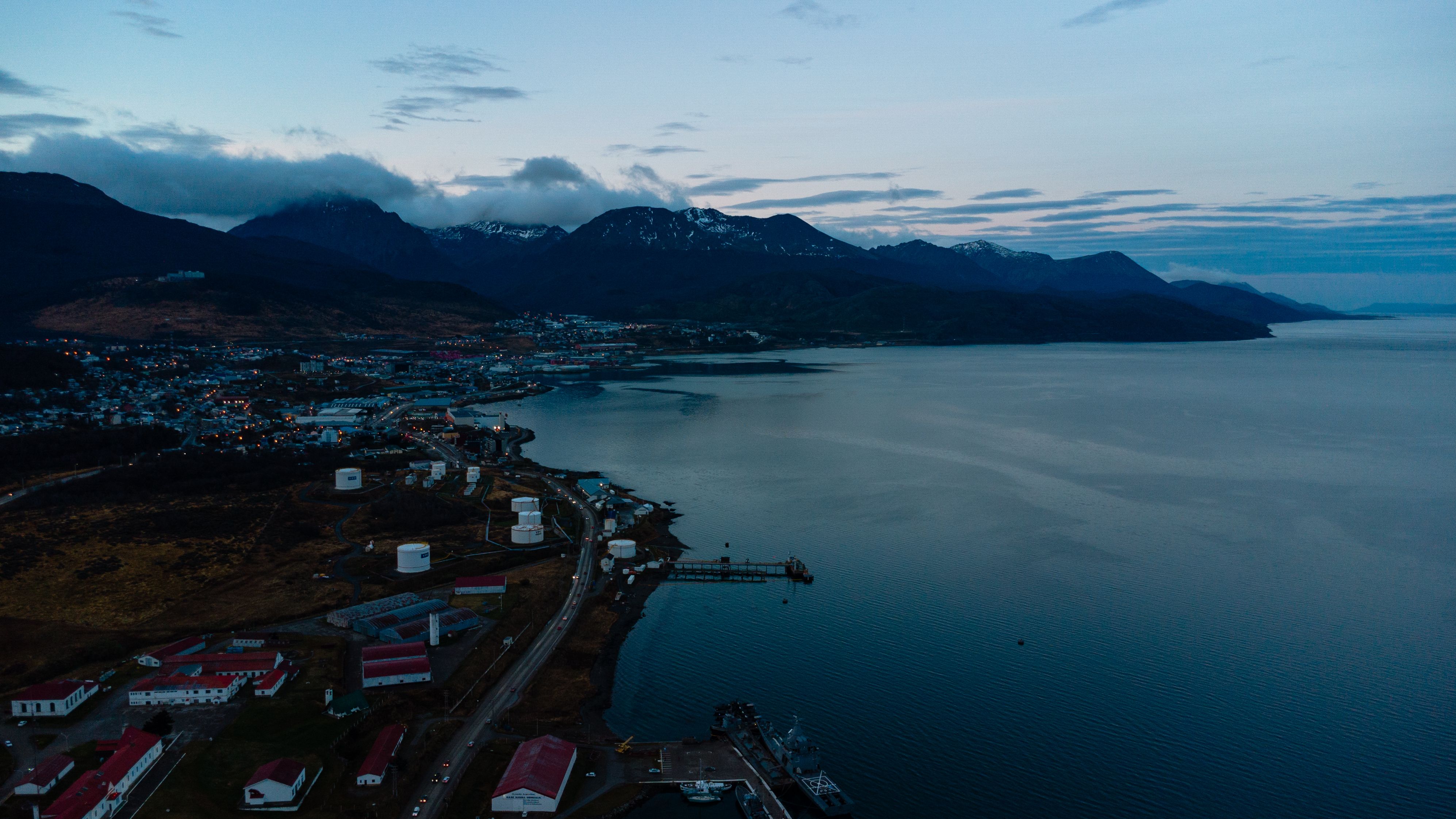 Aerial photo of Ushuaia, Argentina at twilight with mountains and coastline.