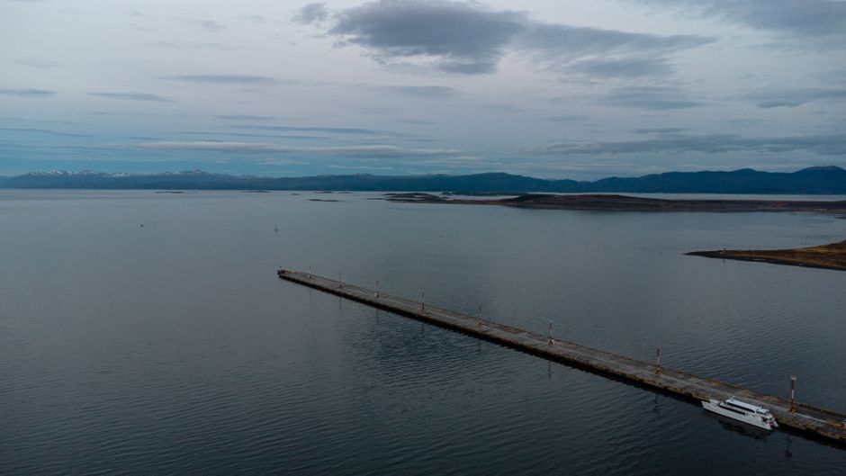 Unbeatable Private Helicopter Tour Review: Soaring Above Buenos Aires and the Paraná Delta Review 2026 - Scenic aerial shot of the Ushuaia pier during twilight, with calm waters and distant mountains.