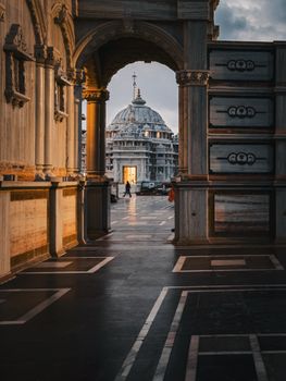 Dramatic sunset view through archway revealing iconic Italian domed architecture.