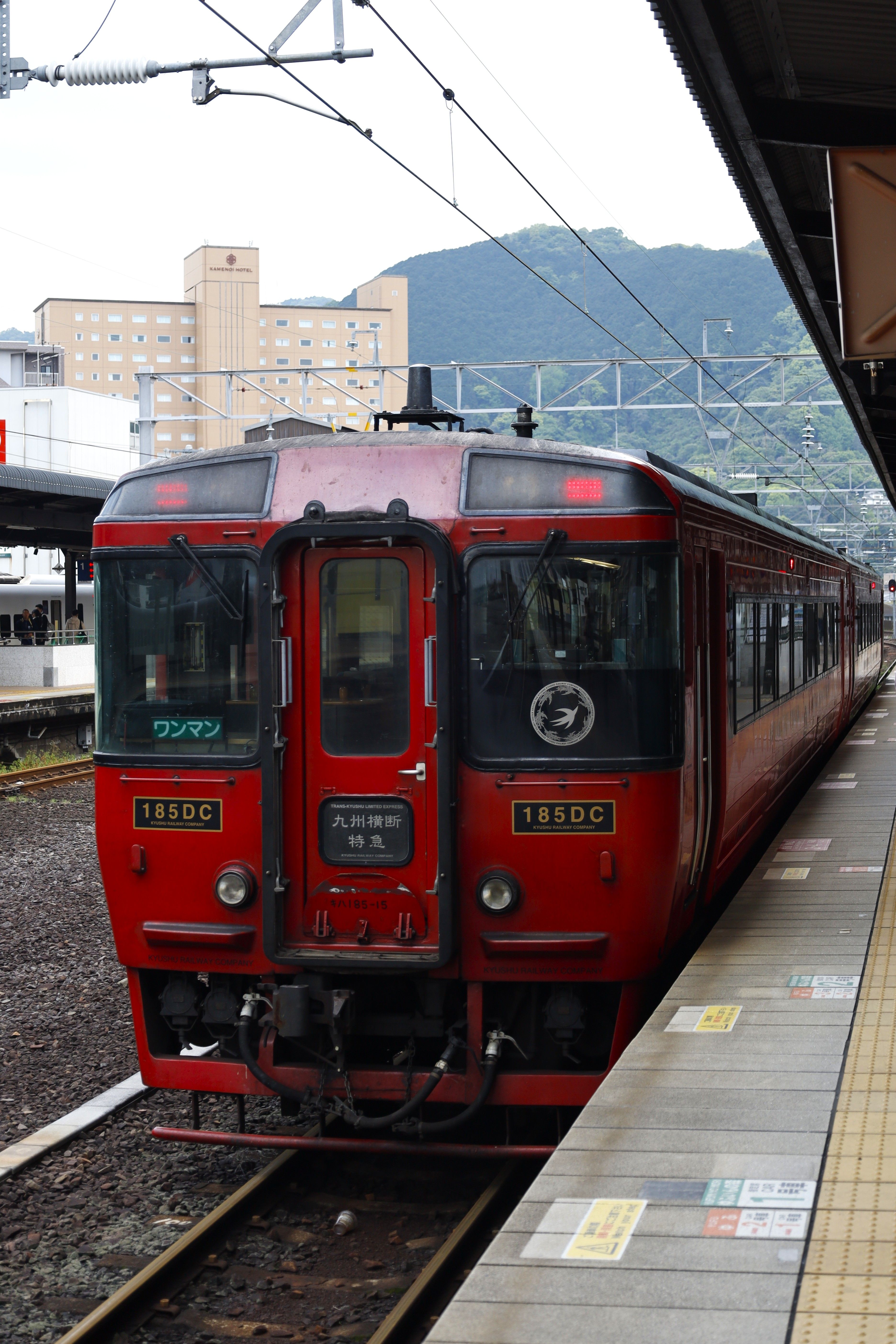 Red Trans-Kyushu limited express train at Beppu station, Oita, Japan on a cloudy day.