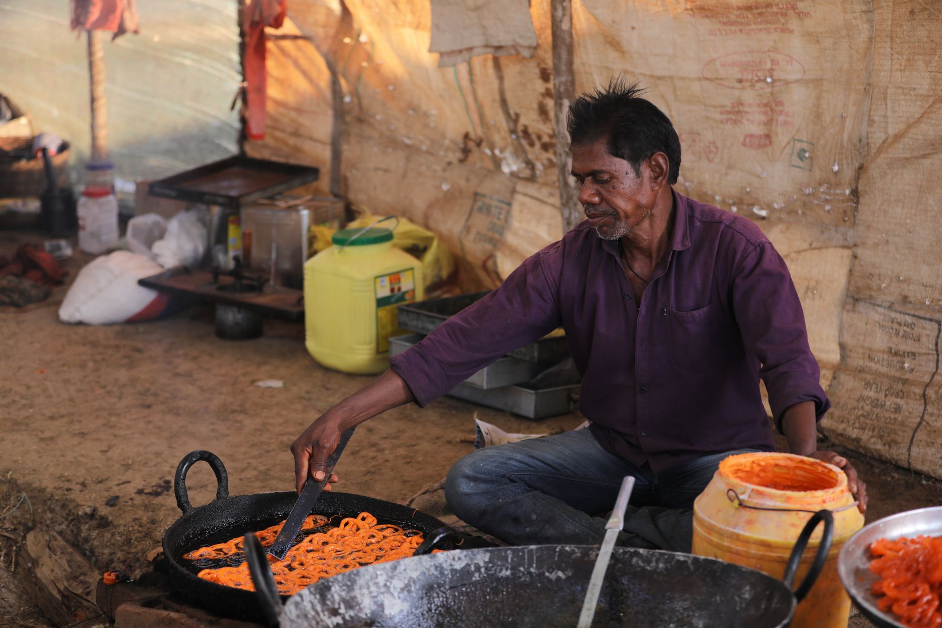 Local artisan cooking jalebi, a traditional Indian sweet, at a street food stall in Chhattisgarh, India.