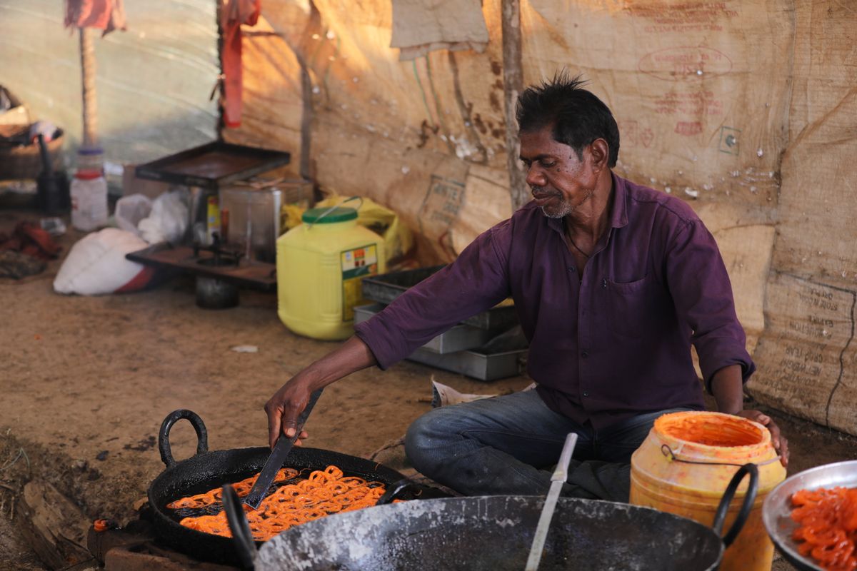 Local artisan cooking jalebi, a traditional Indian sweet, at a street food stall in Chhattisgarh, India.