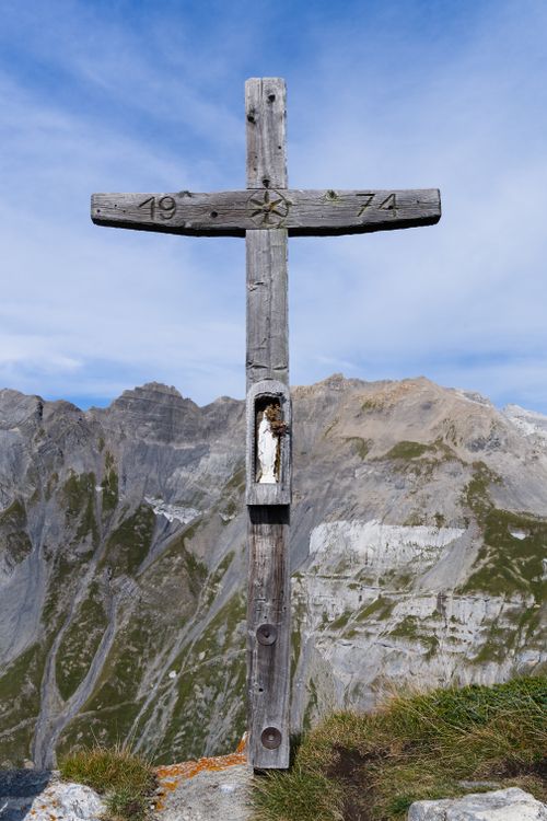Free Wooden cross with Mary statue on Swiss Alps backdrop, under clear skies. Stock Photo