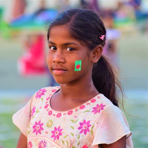 Free Portrait of a young girl with the Bangladesh flag painted on her face in Cox's Bazar. Stock Photo