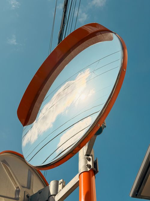 Free A round traffic mirror reflecting clouds and wires under a clear blue sky in Tokyo, Japan. Stock Photo