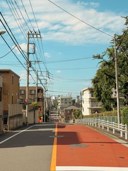 Peaceful, sunny day on a quiet Tokyo street, showcasing urban life.