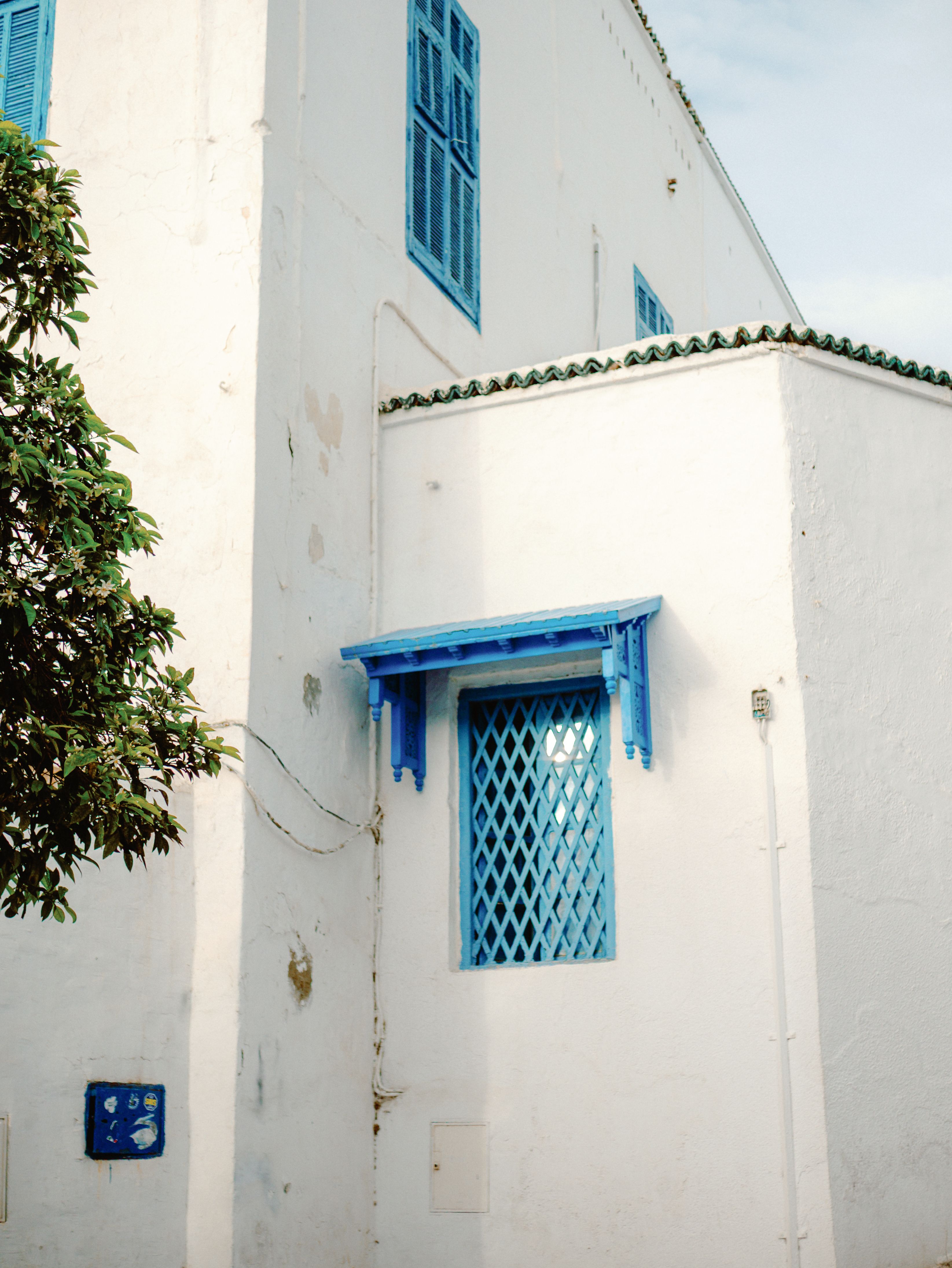 Classic Mediterranean architecture with blue shutters in a sunny setting.