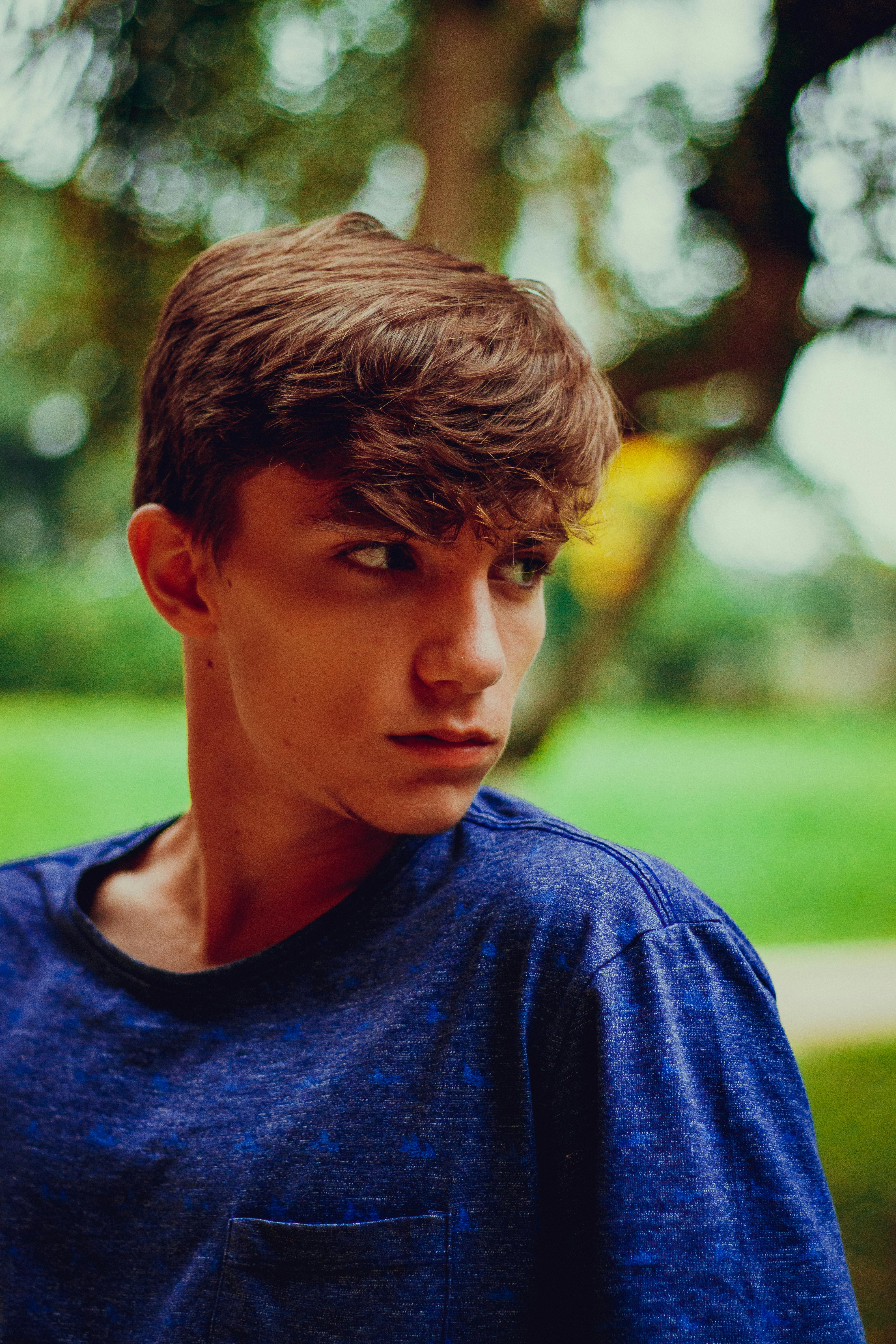一位身穿蓝色衬衫的年轻人在户外沉思的肖像