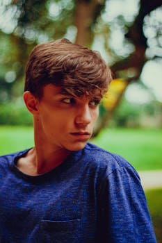 一位身穿蓝色衬衫的年轻人在户外沉思的肖像