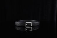 A minimalist photo of a refined black leather belt with a silver buckle, perfect for fashion and accessory themes.